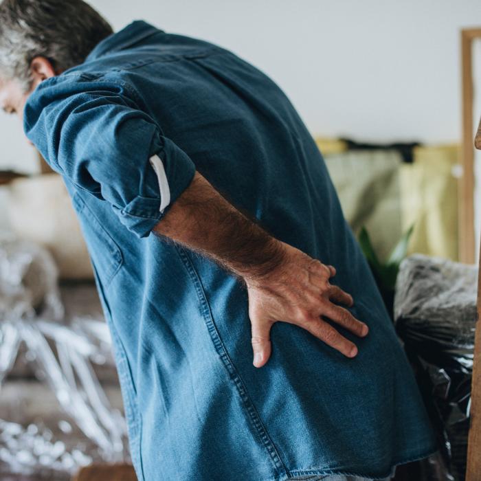 Man gripping his back because it is in pain.