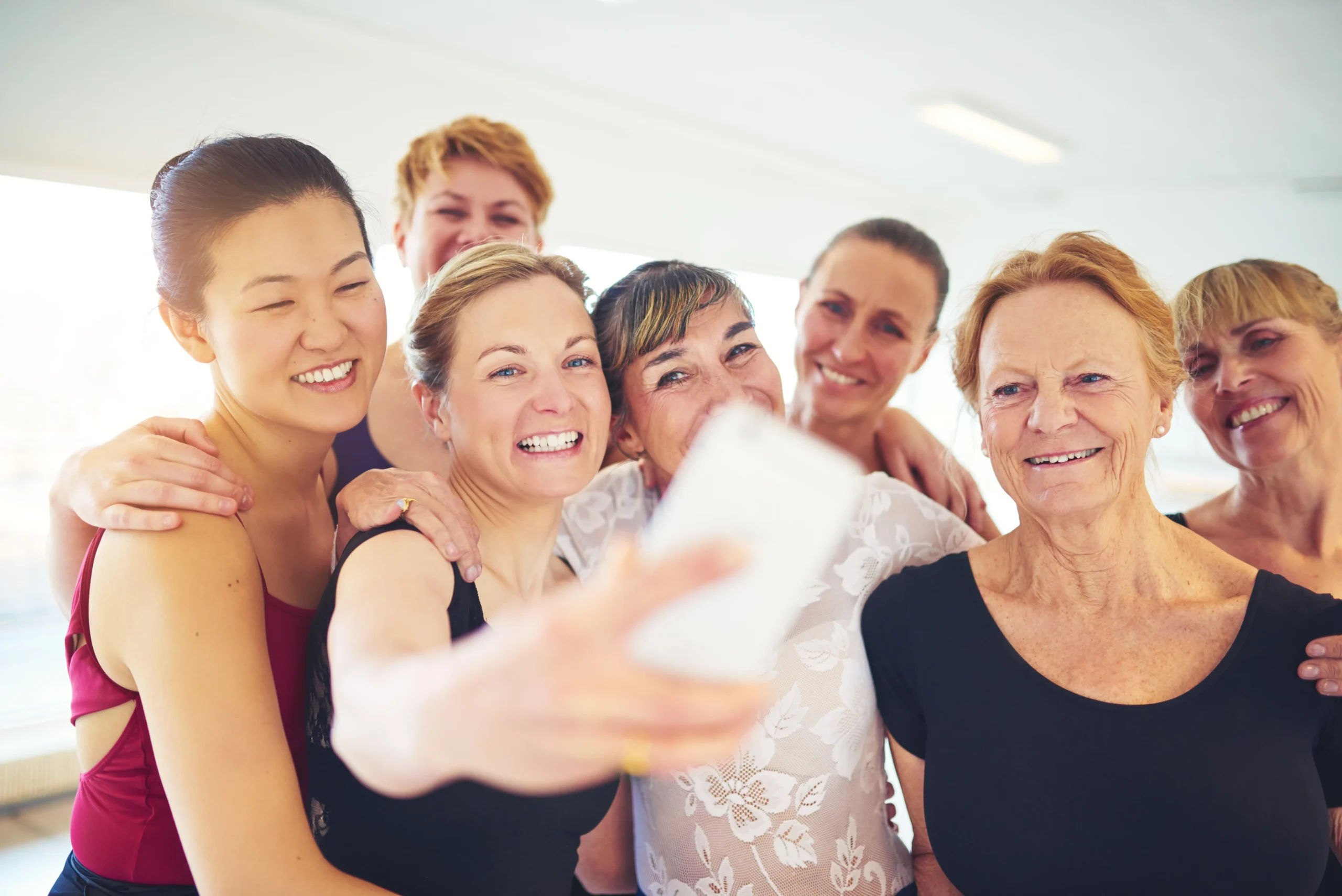 A group of women smiling and taking a selfie, celebrating New Year and their commitment to health with chiropractic care.