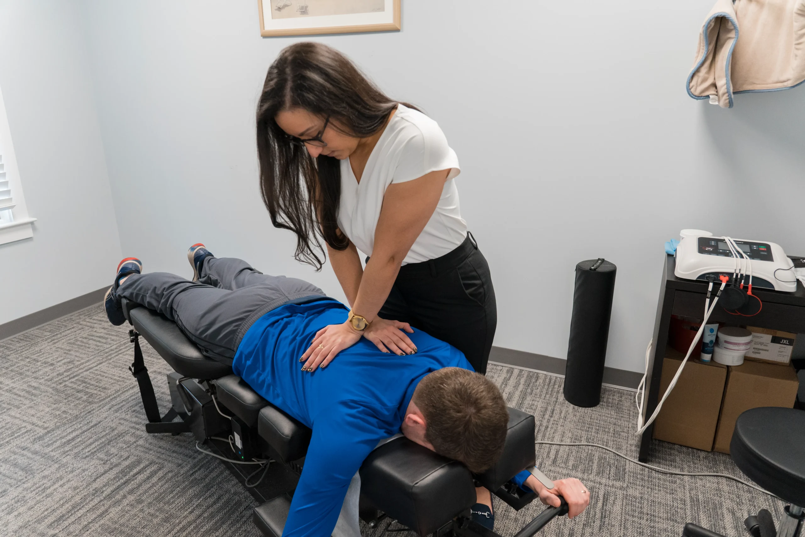 A chiropractor examines a man, emphasizing the role of chiropractic care in improving mobility and reducing back pain.