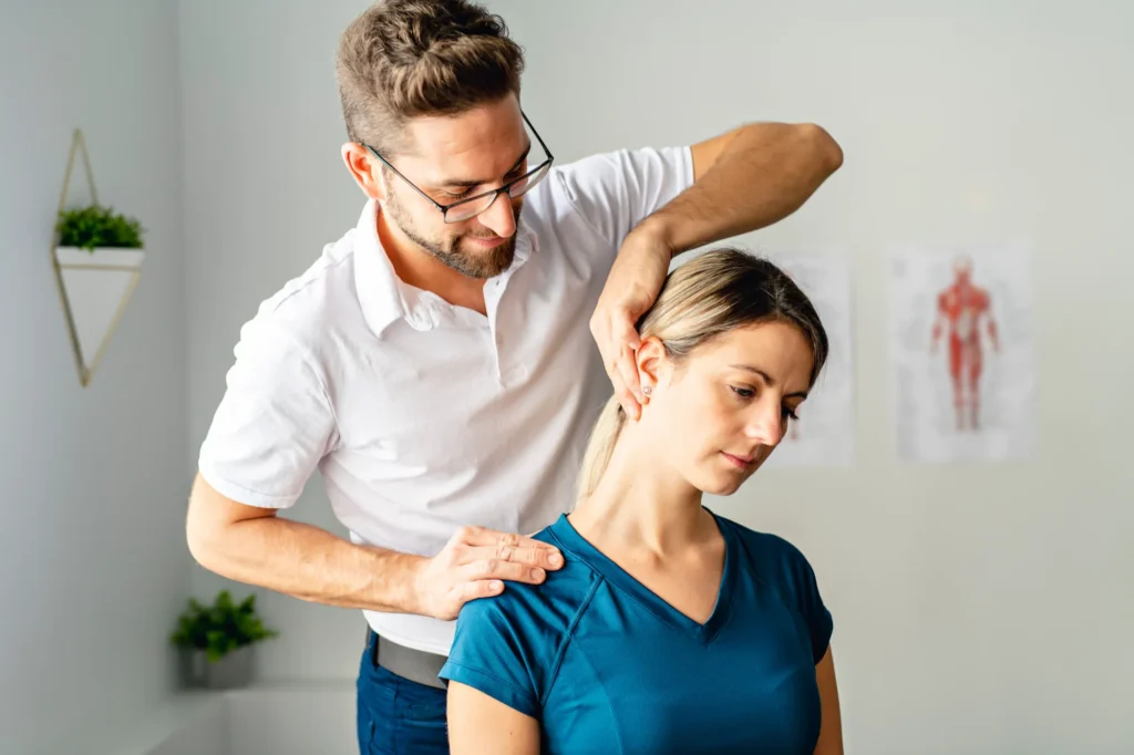 Chiropractor giving care to patient and stretching right side of the neck.