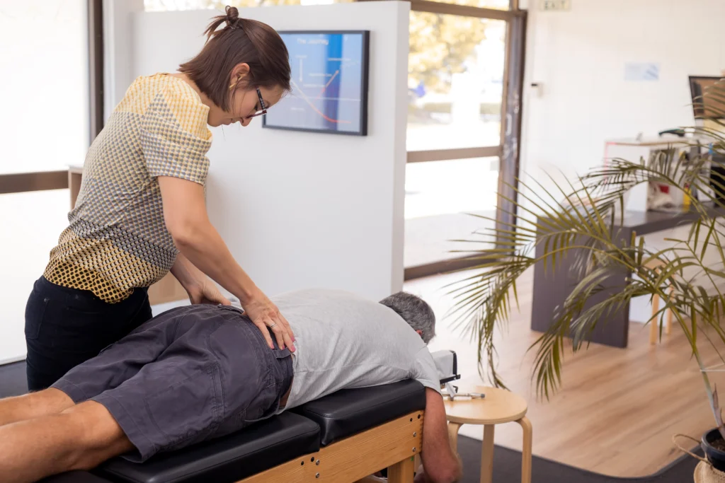 A Chiropractor gives a back massage to a man, emphasizing holistic health and well-being at MCR Chiropractic.