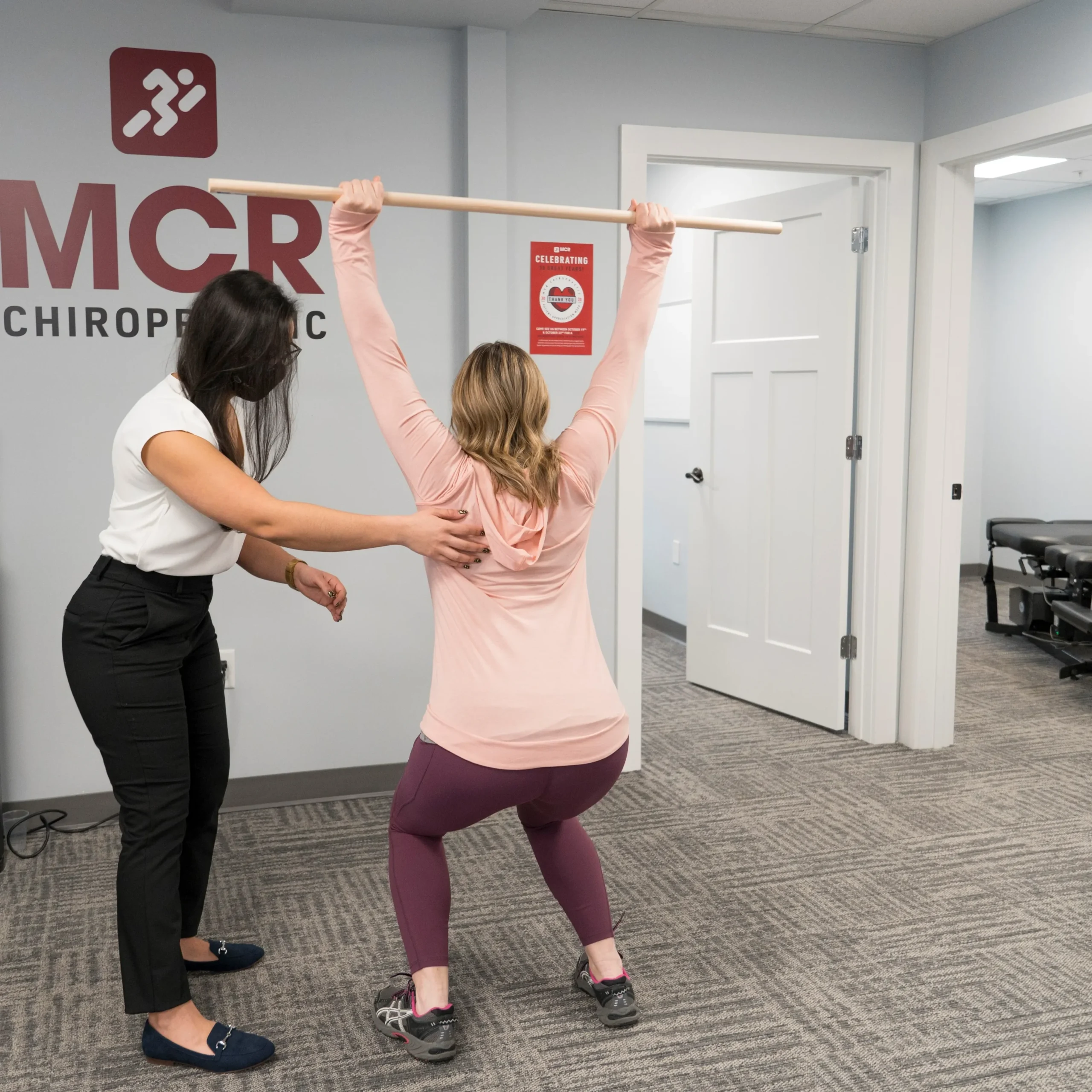 In a MCR Clinic, a woman engages in an exercise guided by the chiropractor, highlighting the importance of holistic health care.