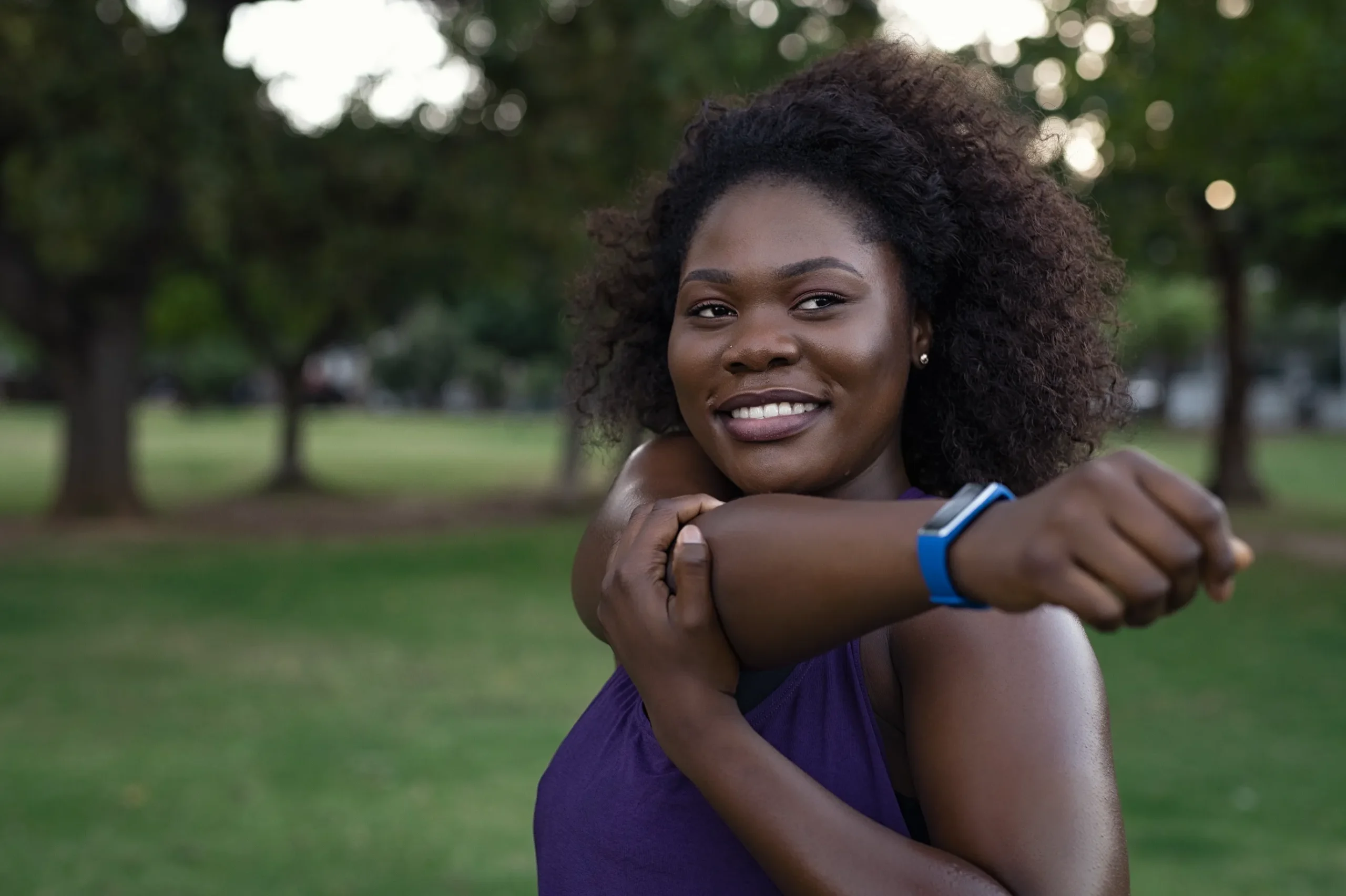 Women stretching her shoulder outside to prevent an injury.