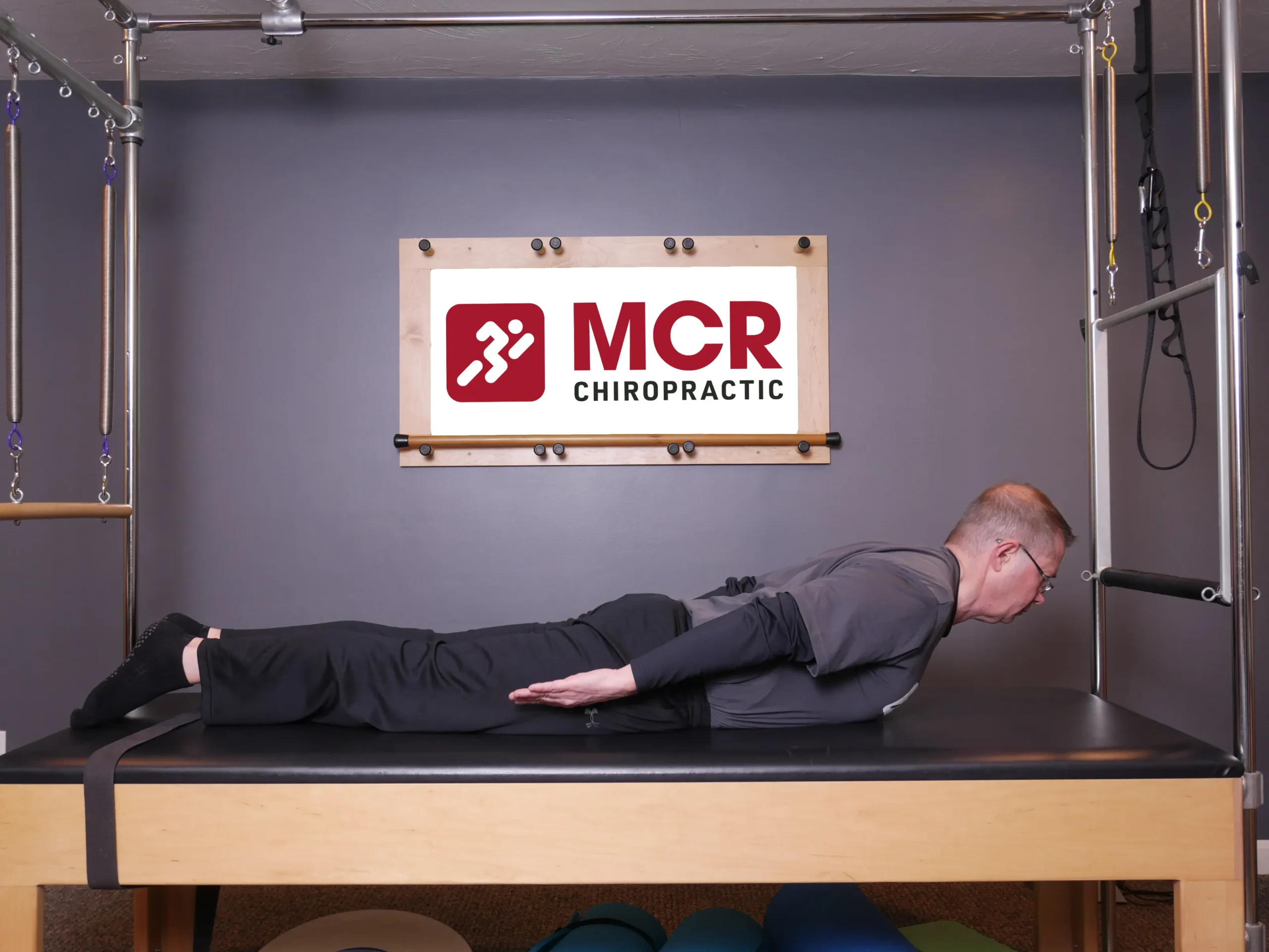 Man laying on the table facedown demonstrating the Darts exercise.