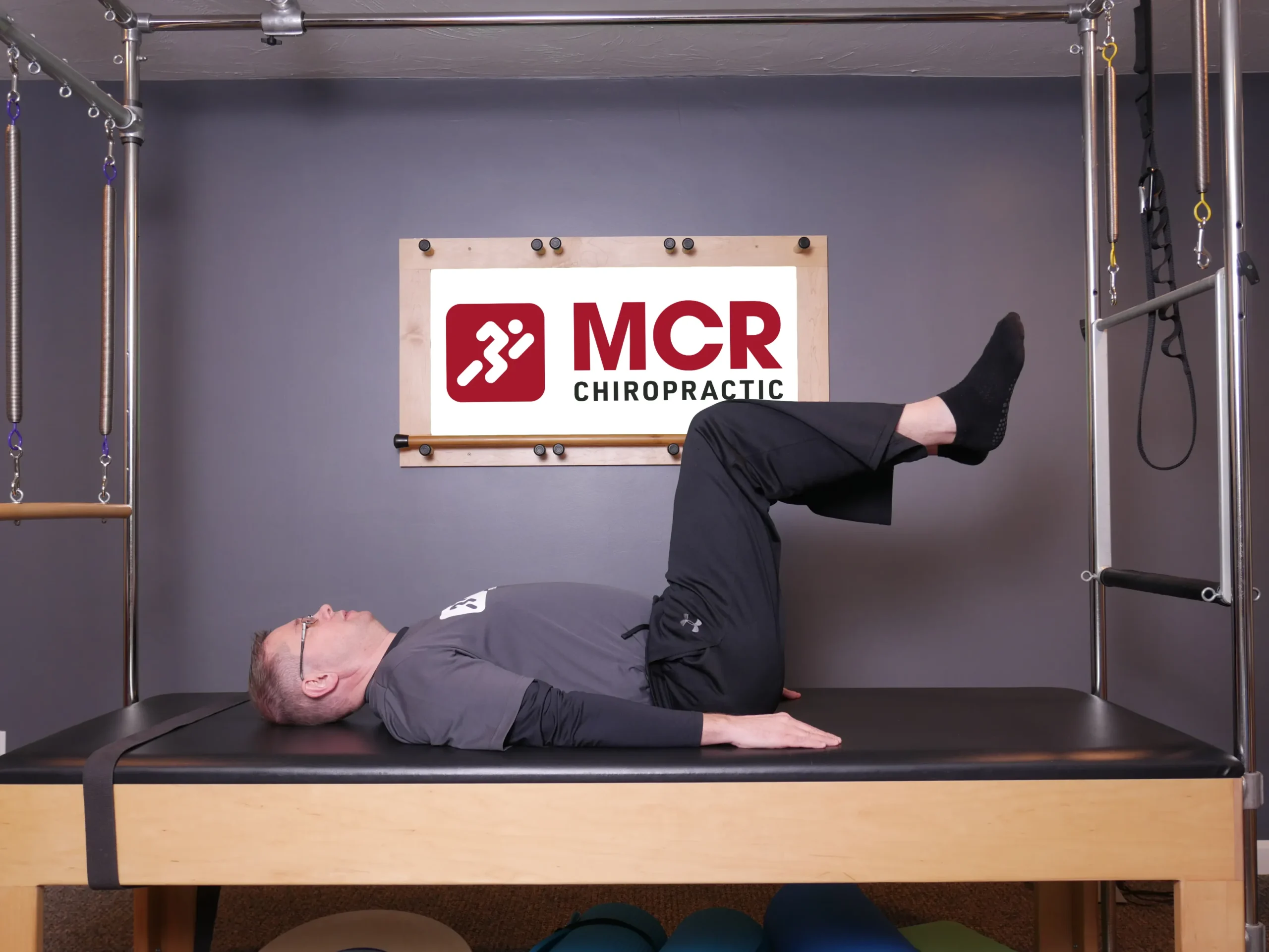 Man laying on table demonstrating the Hundreds exercise.