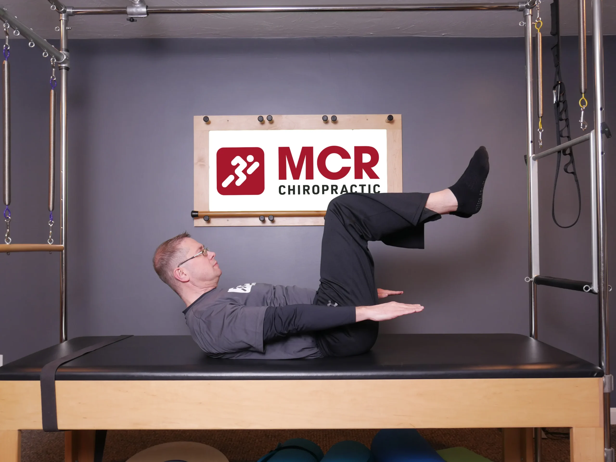 Man laying on table demonstrating the Hundreds exercise.