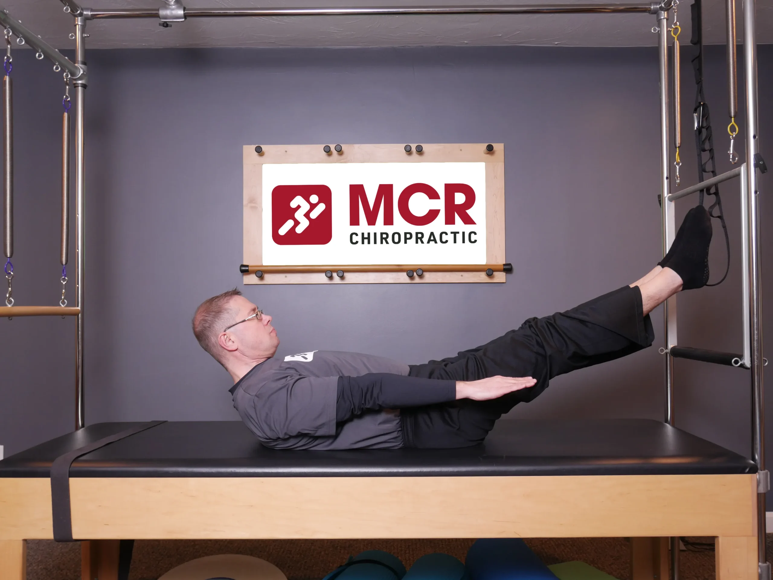 Man laying on table demonstrating the Hundreds exercise.