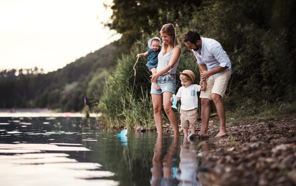 A young family with two children spending time outdoors by the river
