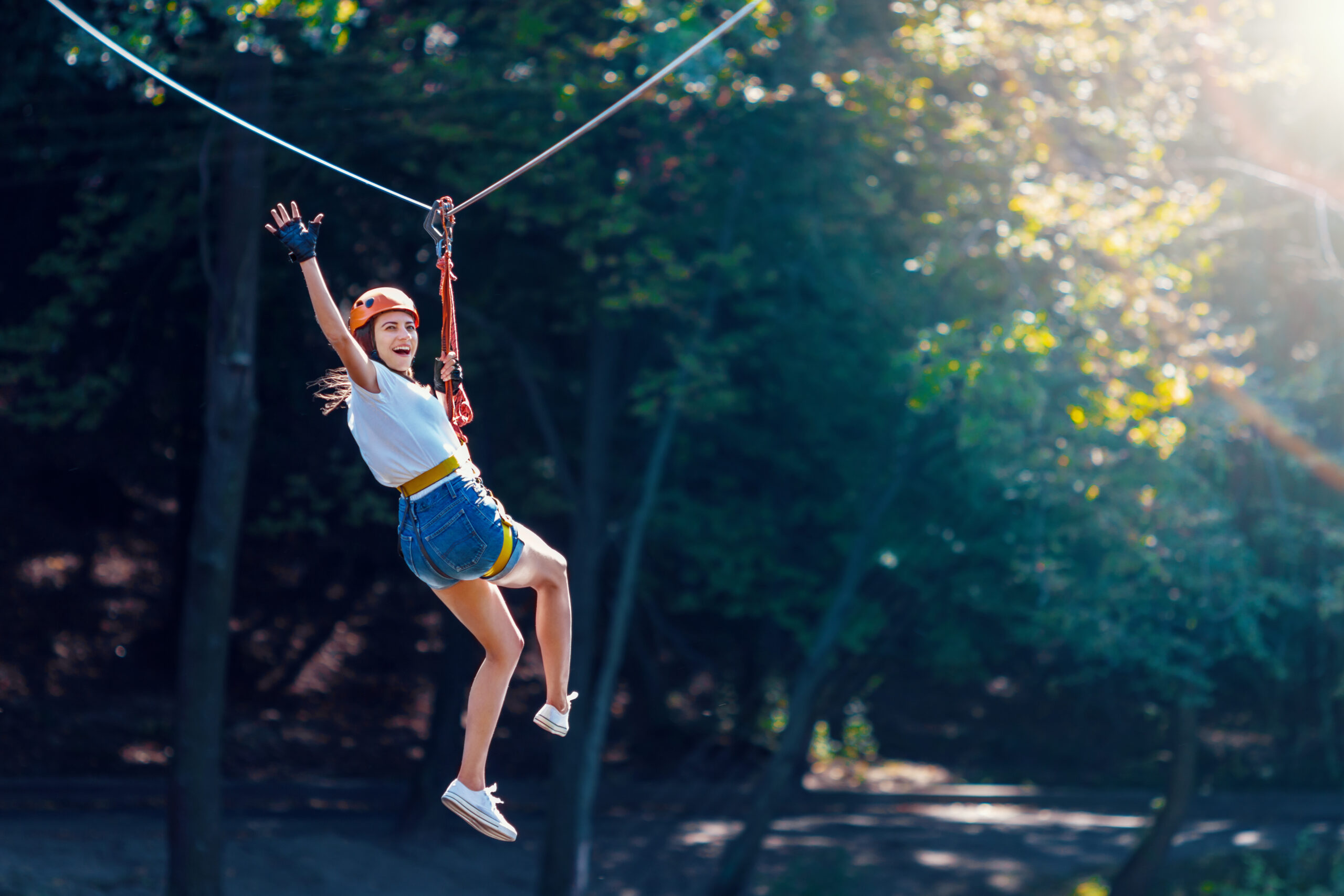 Happy woman on zipline in forest