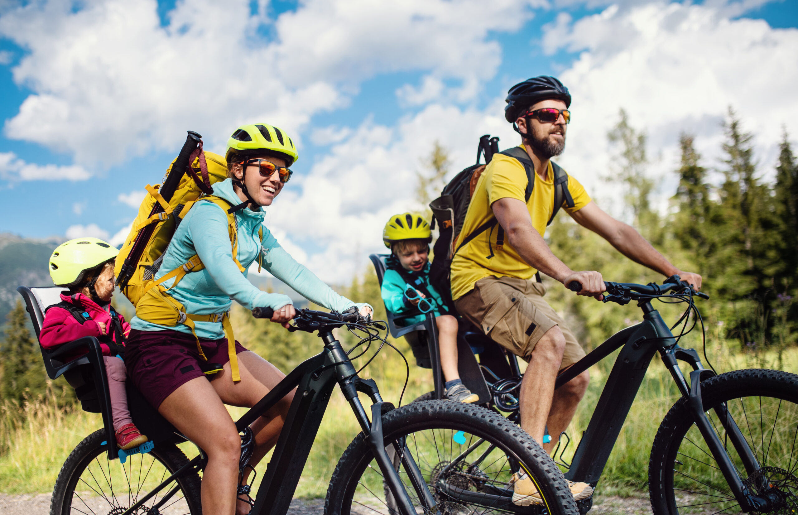 Happy family with small children cycling outdoors